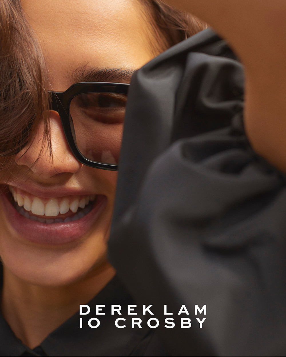 Derek Lam 10 Crosby campaign image of female model wearing black sunglasses and smiling to the camera – women's luxury eyewear fashion photography.