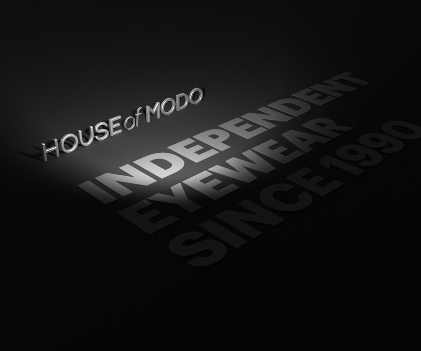 3D HOUSE of MODO logo with ‘Independent Eyewear Since 1990’ text on dark grey surface – premium independent eyewear branding.