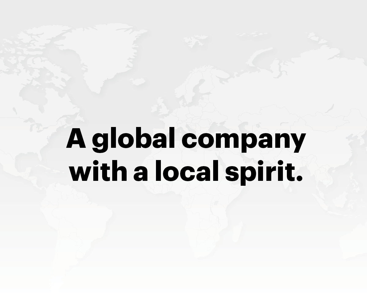 Graphic image featuring a world map background with text overlay ‘A global company with a local spirit.’
