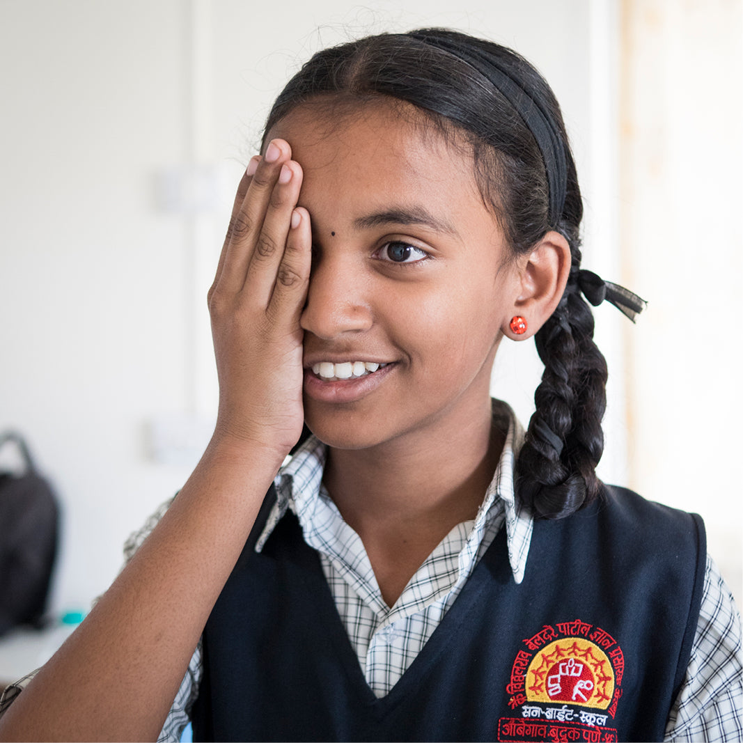 Close-up of a child undergoing an eye exam, symbolizing the positive impact of MODO Eyewear’s ‘Buy a Frame, Help a Child See’ program.