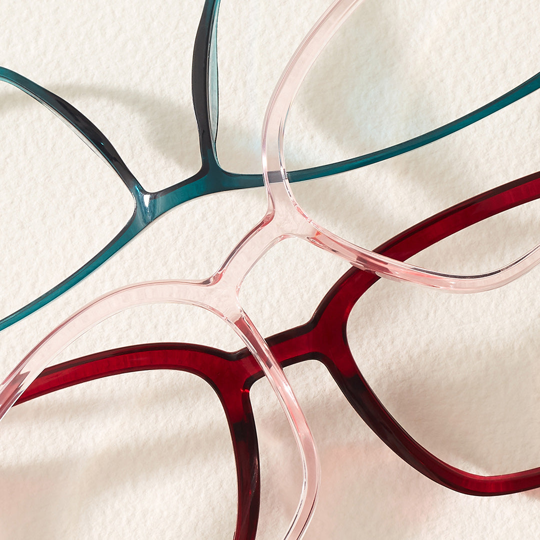 Close-up of three eyeglass frame fronts made from memory plastic, casually arranged on a surface to showcase innovative eyewear materials.