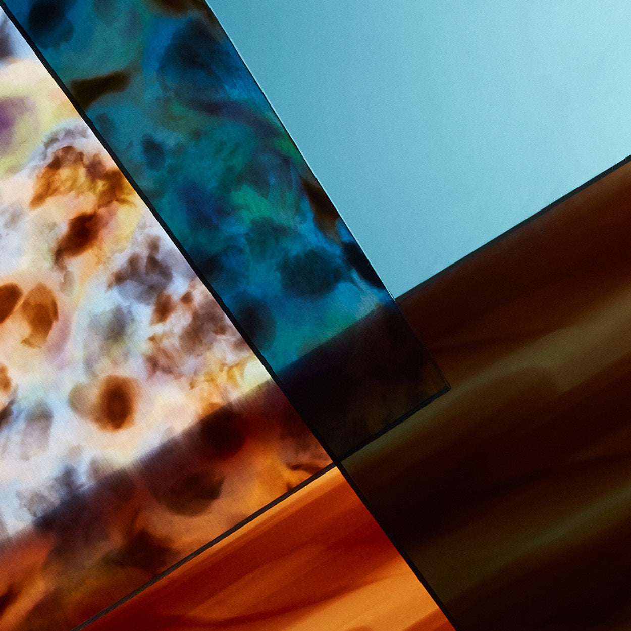 Flatlay of multicolored and patterned high-density acetate pieces laying together, showcasing eyewear material options.