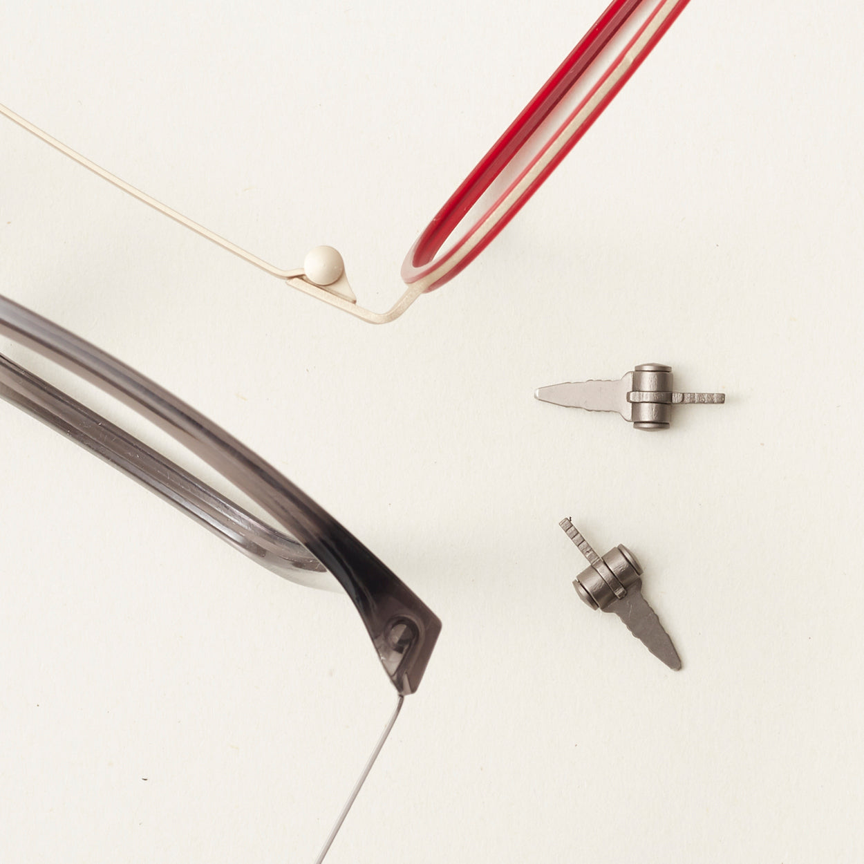 Flatlay of two eyeglass frames showcasing just part of them and two hinges.